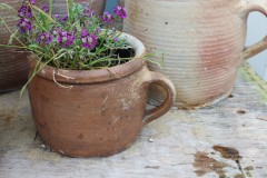 Oude ronde bruine aardewerk pot met oor